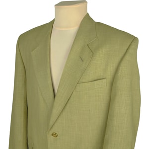 May include: A light green blazer with a two-button closure and a chest pocket. The blazer is displayed on a mannequin with a cream-colored shirt underneath. The fabric has a subtle texture.