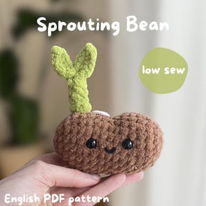 May include: A crocheted bean sprout plushie with a smiling face. The bean is brown, with a green sprout emerging from the top. The text "Sprouting Bean" and "low sew" are visible.