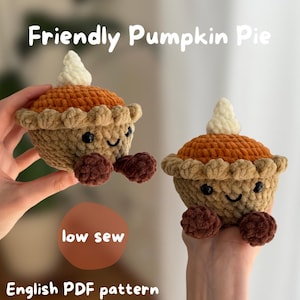 May include: Two crocheted pumpkin pie plushies with orange tops, tan crusts, and white whipped cream dollops. Each features black safety eyes and a stitched smile, with dark brown feet. Text reads: Friendly Pumpkin Pie, low sew, English PDF pattern.
