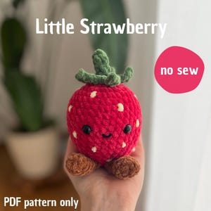 Puede incluir: Una fresa roja tejida a mano con puntos blancos, hojas verdes y pies marrones. La fresa tiene una cara sonriente con ojos negros. El texto de la imagen dice "Little Strawberry", "no sew" y "PDF pattern only".