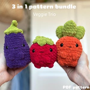 Könnte beinhalten: Ein Häkelmuster-Paket zum Erstellen von drei Amigurumi-Gemüse: einer lila Aubergine, einer roten Erdbeere und einer orangefarbenen Karotte. Das Muster heißt "Veggie Trio" und ist als PDF-Download erhältlich.