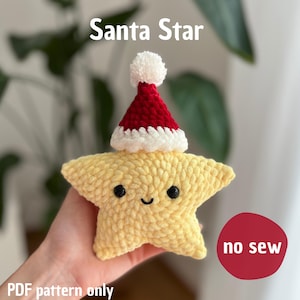 Puede incluir: Una estrella amarilla tejida con un gorro de Papá Noel. La estrella tiene ojos negros y una boca sonriente. El gorro de Papá Noel es rojo con ribete blanco y un pompón blanco. El texto en la imagen dice "Santa Star", "no sew" y "PDF pattern only".