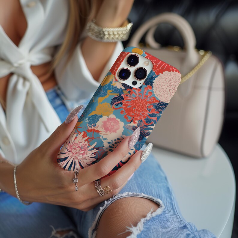 May include: A phone case with a floral design featuring red, pink, blue, and yellow flowers. The case has a camera lens cutout and a textured surface.