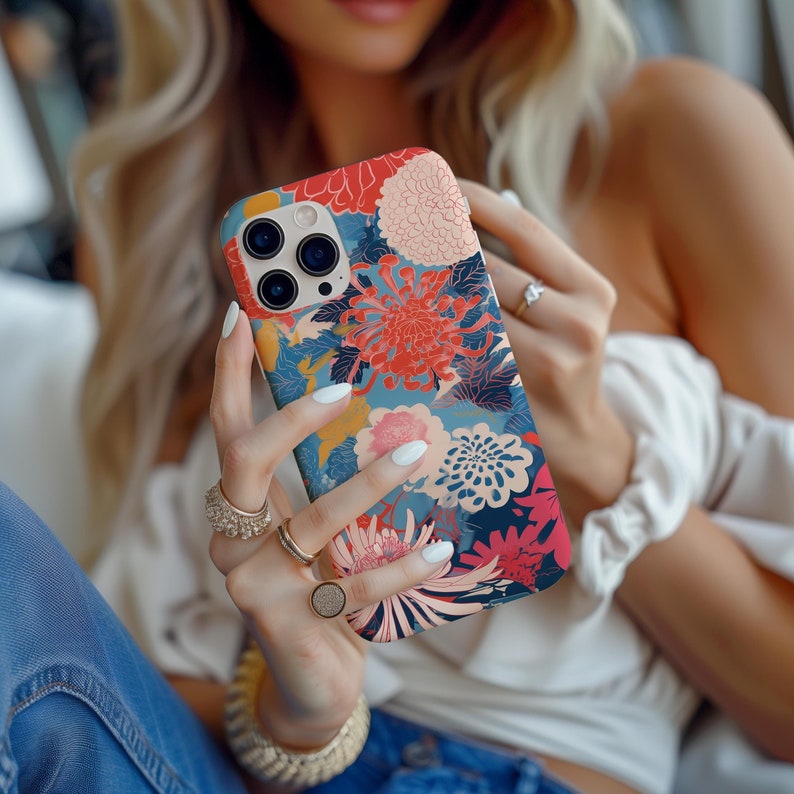 May include: A phone case with a floral design featuring red, pink, and blue flowers. The case has a clear back and a raised lip around the camera lens.