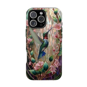 May include: A phone case featuring a colorful hummingbird with outstretched wings, surrounded by pink flowers and green leaves. The background has a stained-glass effect. The case has a black border and a camera cutout.
