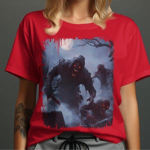 Puede incluir: Camiseta roja con un estampado gráfico de zombis en una escena brumosa a la luz de la luna. Los zombis tienen ojos rojos brillantes y visten ropa oscura. La camiseta es de color rojo liso.
