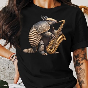 Einzigartiges Gürteltier, das Saxophon-Grafik-T-Shirt, Tiermusik-Liebhaber-T-Stück, schrulliges lustiges Hemd-Design spielt