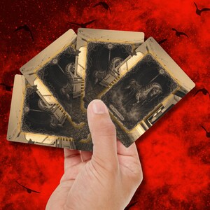 May include: A hand holding a fan of tarot cards. Each card features a black and white illustration of a horse-drawn carriage. The cards have a gold border and are set against a red background with black bird silhouettes.