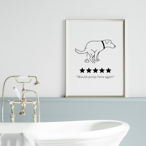 Puede incluir: Un cuadro enmarcado con una ilustraci&oacute;n en blanco y negro de un perro defecando, con cuatro estrellas y el texto "Would poop here again". La obra de arte se exhibe en un ba&ntilde;o con una ba&ntilde;era blanca y accesorios plateados.