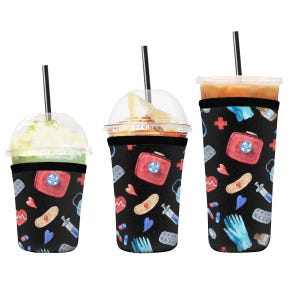 May include: Three different sizes of black neoprene drink sleeves with a colorful pattern of medical supplies, including a red first aid kit, bandages, pills, and blue medical gloves. The sleeves are designed to fit around a variety of cups and tumblers.