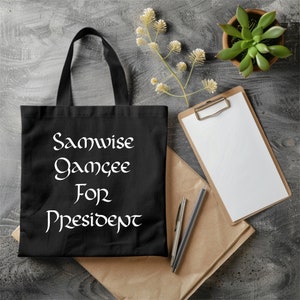 May include: Black tote bag with white text that reads "Samwise Gamgee for President".