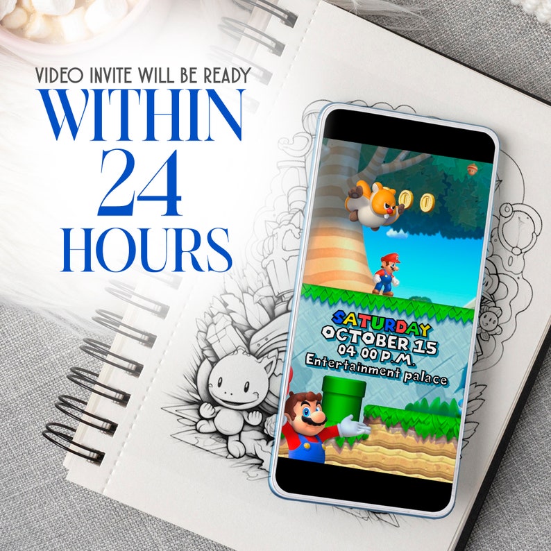 May include: A smartphone displays a colorful video game scene with Mario. Text on the screen reads "SATURDAY OCTOBER 15 04:00 PM Entertainment palace." The image is on a spiral-bound notebook with the text "VIDEO INVITE WILL BE READY WITHIN 24 HOURS."