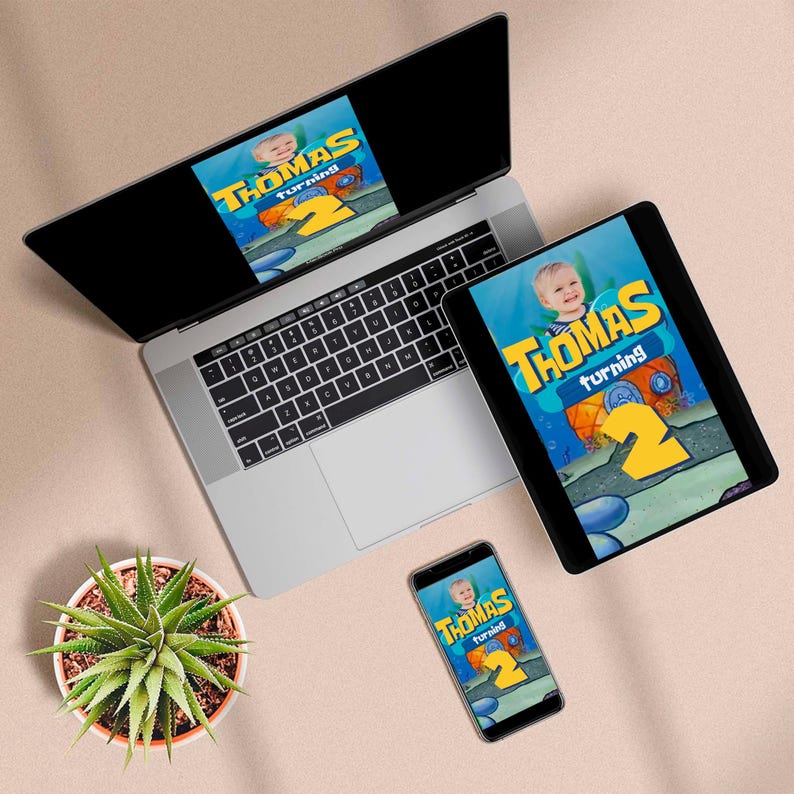 Pu&ograve; includere: Un laptop, un tablet e uno smartphone mostrano un invito di compleanno con la scritta "Thomas turning 2". Il design presenta un tema a cartoni animati con la foto di un bambino ed elementi sottomarini. &Egrave; visibile anche una pianta in vaso.