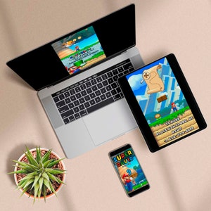 May include: A laptop, tablet, and smartphone display a colorful video game scene featuring a character. The tablet shows a treasure map and the text "75 PARK PLACE 6TH FLOOR NY RSVP +1 212-744-8000". The phone says "SUPER DAVID 9th Birthday". A succulent plant sits nearby.
