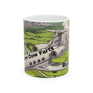May include: White ceramic mug with a cartoon image of a jet plane over green hills. The plane has the text "Lime Cow Farts". The mug has a glossy finish and a standard handle. The mug is suitable for hot or cold drinks.