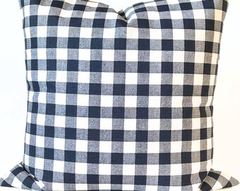 May include: Square pillow with a navy blue and white buffalo check pattern. The pillow is a decorative item, likely for a bed or sofa. The fabric has a classic, farmhouse style.