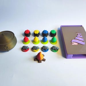 以下が含まれることがあります： ボードゲーム用のゲームピースのセット。ピースには、大釜、火、金貨の積み重ね、ネズミのセットが含まれています。ピースはすべてプラスチック製で、さまざまな色に塗られています。