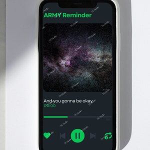 May include: A smartphone displaying a music player app with the song "ARMY Reminder" playing. The song title is in green text. The album art is a photo of a starry night sky. The song is at the beginning, 0:00, and the play button is paused.