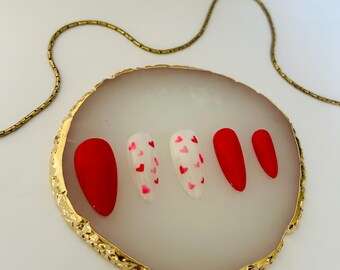 May include: Set of five press-on nails. Two nails are red and three nails are white with pink hearts.