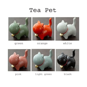 May include: Six ceramic cat tea pets in different colors: green, orange, white, pink, light green, and black. Each cat has a bell on its collar.
