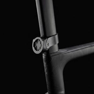 May include: A close-up of a black bicycle frame with a seat post and a mounted computer holder. The frame has a textured pattern and the brand name "X-LAB" is visible. The computer holder is circular and has a central mounting point.