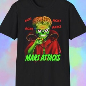 May include: Black t-shirt featuring a green Martian character with a large brain, red eyes, and a red cape. The words "ACK!" are printed in red, and "MARS ATTACKS" is in green, creating a bold graphic design.