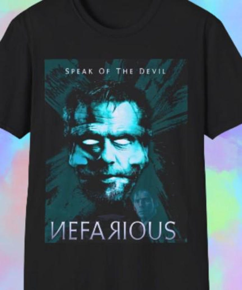 Może przedstawiać: Czarny t-shirt z turkusowo-niebieską grafiką przedstawiającą twarz mężczyzny. Tekst "SPEAK OF THE DEVIL" znajduje się powyżej, a "NEFARIOUS" poniżej. Grafika ma styl vintage.