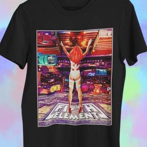 May include: Black t-shirt with a graphic from "The Fifth Element." The image shows a woman with red hair and a white outfit, arms raised, with the film's title at the bottom. The background is a futuristic cityscape with various vehicles.