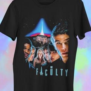 Może przedstawiać: Czarny t-shirt z projektem plakatu filmowego. Grafika zawiera grupę ludzi, budynek i tekst "THE FACULTY" w jasnoniebieskim kolorze. Tło ma niebieską i czerwoną wiązkę światła.