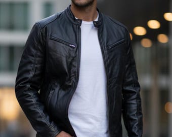 Può includere: Giacca in pelle nera con collo alto e tasche con cerniera. La giacca è indossata sopra una maglietta bianca e abbinata a jeans grigio scuro. L'immagine è scattata all'aperto.
