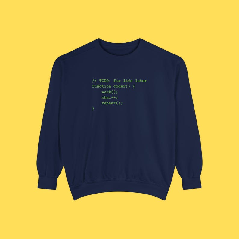 A dark blue crewneck sweatshirt featuring green programming text centered on the chest against a solid yellow background.