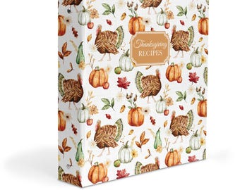 May include: A white three-ring binder featuring a repeating watercolor pattern of brown turkeys, orange pumpkins, white gourds, and autumn leaves. A central rectangular label with a decorative border displays the text Thanksgiving RECIPES.