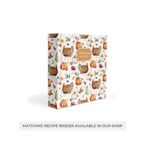 May include: A white recipe binder with a Thanksgiving theme. The cover features a repeating pattern of turkeys, pumpkins, and fall leaves. The text "Thanksgiving Recipes" is printed in brown on the cover.