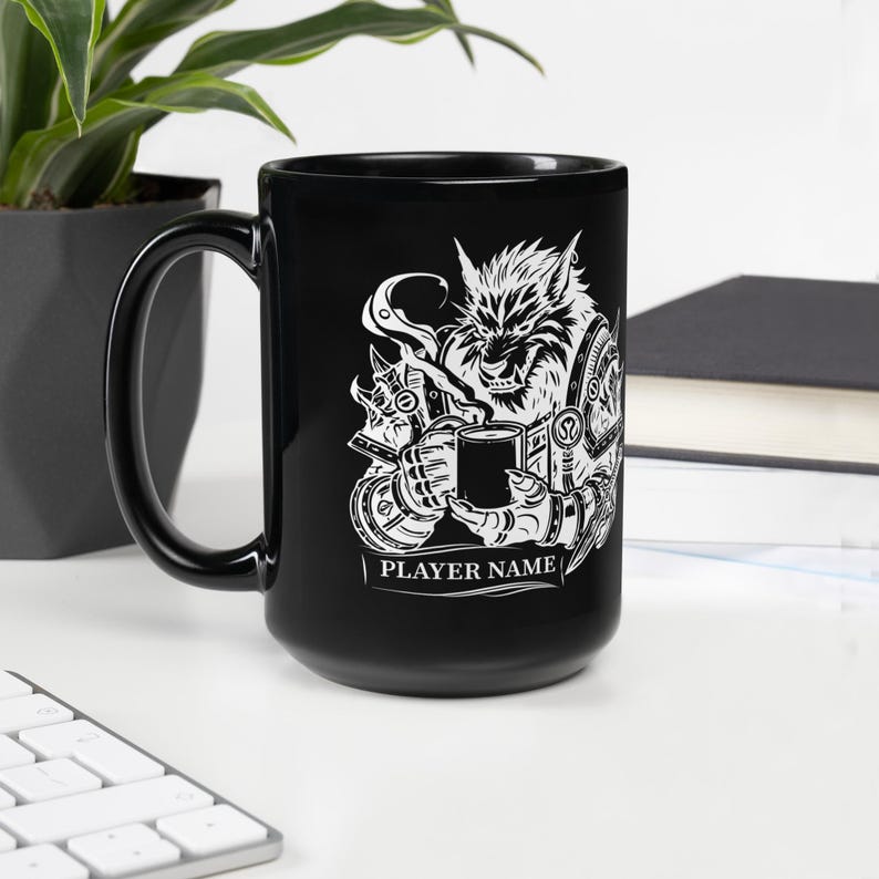 K&ouml;nnte beinhalten: Schwarze Keramiktasse mit einer wei&szlig;en Grafik eines Werwolfs, der eine Tasse Kaffee h&auml;lt. Das Design enth&auml;lt den Text "PLAYER NAME" am unteren Rand. Die Tasse steht auf einer wei&szlig;en Oberfl&auml;che.