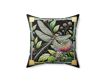 Puede incluir: Una almohada negra con un diseño colorido de libélula y flores. La libélula es azul, verde y amarilla, y las flores son rosas, moradas y blancas. El fondo es negro con un efecto de vitral.