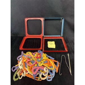 May include: An open red and blue Looper Ties kit with a pile of colorful yarn and two white tools. The kit includes two square frames with black interiors and a small yellow tag that reads "Looper Ties".
