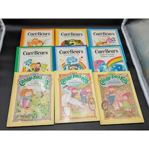 May include: A collection of children's books featuring Care Bears and Cabbage Patch Kids. The Care Bears books have colorful covers with illustrations of the bears and rainbows. The Cabbage Patch Kids books have illustrations of children and animals.