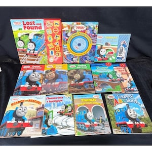 May include: A collection of eleven Thomas & Friends children's books featuring various titles including Lost and Found, Thomas Gets a Snowplow, and Thomas ABC Book. The books display colorful illustrations of Thomas the Tank Engine and friends.