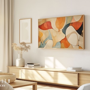 Könnte beinhalten: Ein Wohnzimmer-Interieur mit einem hellen Holzunterhaltungszentrum, auf dem ein gerahmtes abstraktes Gemälde mit geometrischen Formen in Orange-, Rot-, Gelb-, Blau- und Weißtönen hängt. Das Gemälde hängt an einer weißen Wand über dem Unterhaltungszentrum. Auf dem Unterhaltungszentrum steht eine Vase mit getrockneten Blumen.
