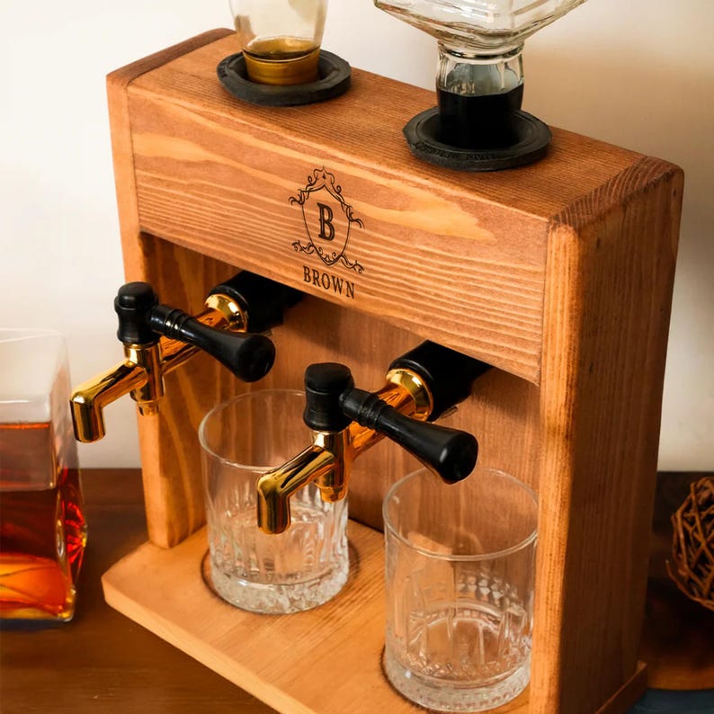 A wooden dispenser with two glass taps, one for each glass, and a glass bottle on top. The dispenser has a wooden exterior and a black handle.