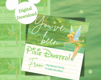 May include: A green printable tag with a Tinkerbell illustration. The tag says "You've been Pixie Dusted! From: The (Name) Family in Cabin (Number)"