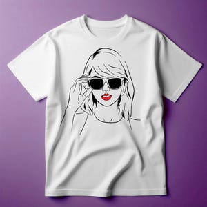 May include: White t-shirt with a black and white line drawing of a woman wearing sunglasses and red lipstick.