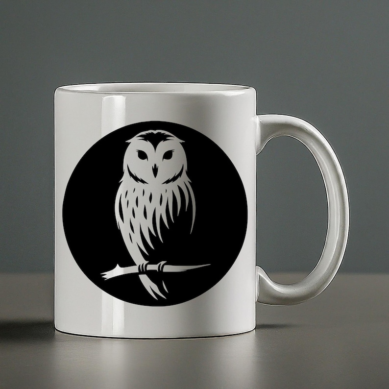 Op de afbeelding: Witte keramische mok met een zwart-wit silhouet van een uil die op een tak zit. De uil kijkt naar voren met zijn vleugels uitgespreid.