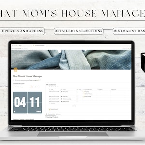 May include: A laptop computer displaying a website called "That Mom's House Manager". The website has a minimalist dashboard with a calendar, cleaning projects, and a list of chores. The laptop is on a white wooden surface.