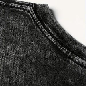 May include: Close-up of the neckline of a black t-shirt with a distressed, faded look. The fabric has a textured, worn appearance.