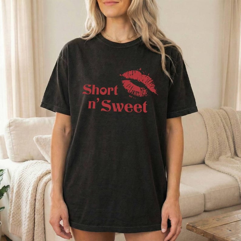 May include: Black t-shirt featuring the red text "Short n' Sweet" and a red lip print. The shirt has a crew neck and short sleeves.