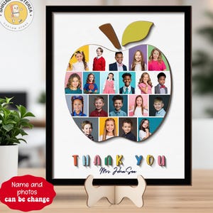 May include: A framed apple-shaped photo collage with student portraits. The apple is filled with colorful photos, and the words "THANK YOU" are displayed below, along with a teacher's name. A wooden stand supports the frame.