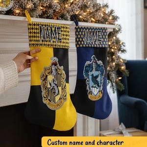 Puede incluir: Dos calcetines navideños personalizados con nombres y diseños de personajes. Uno es amarillo y negro con un escudo y la palabra "Hufflepuff". El otro es azul y negro con un escudo y la palabra "Ravenclaw". Los calcetines tienen un patrón de diamantes en la parte superior.