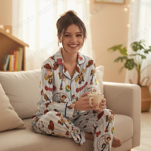 Puede incluir: Un conjunto de pijama de dos piezas que consta de una camisa de manga larga con botones y pantalones a juego. La tela es de rayas azul claro y blancas con un patrón repetitivo del personaje Woody de Toy Story, incluyendo su sombrero, botas y lazo.