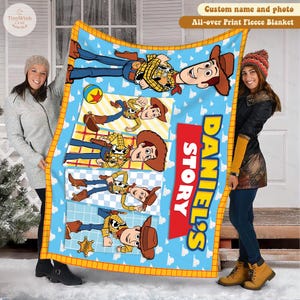 Może przedstawiać: Niebieski polarowy koc z postacią Woody'ego z Toy Story. Koc ma jasnoniebieskie tło z białymi chmurami i ż&oacute;łtą obw&oacute;dką. Na kocu wydrukowano napis "DANIEL'S STORY".